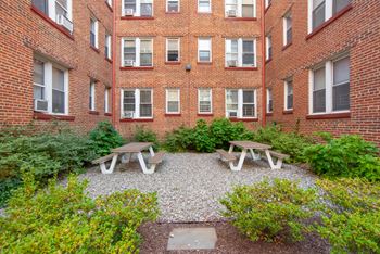 Resident-only courtyard with landscaped white gravel terrace / picnic tables